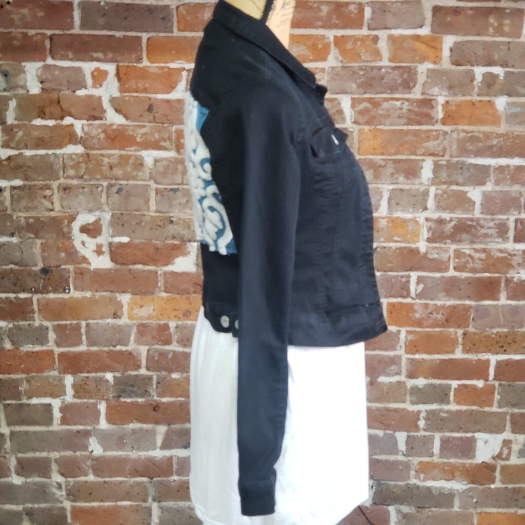 "Blue Moon" Upcycled Denim Jacket, black denim jacket - Almost Famous Brand, Size Medium. Cotton/poly with spandex. An applique was created with awesome turquoise and white embroidery crafted on the back of this jacket. side veiw